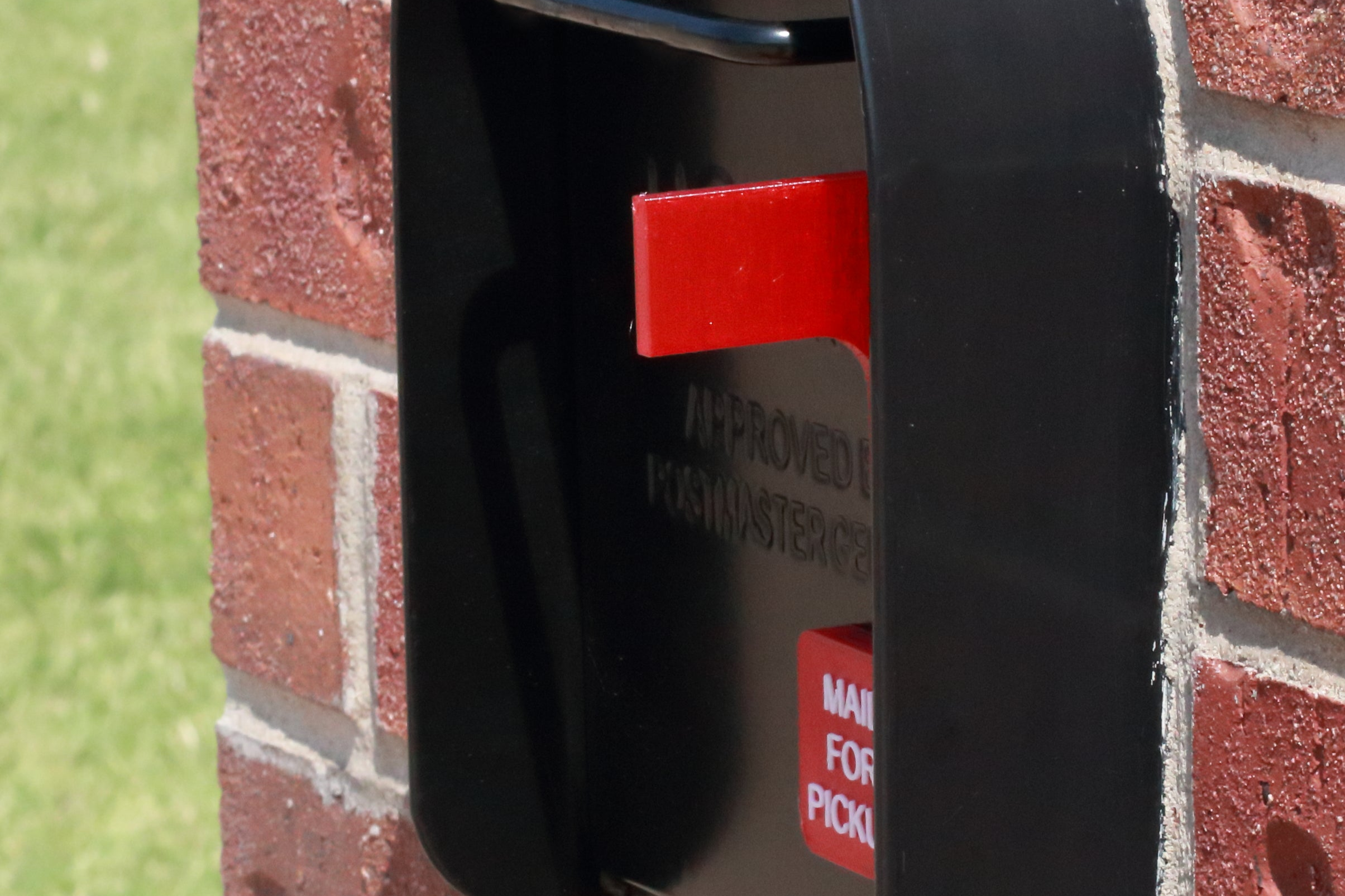 Red flag on the front of a black mailbox that reads Mail for Pickup