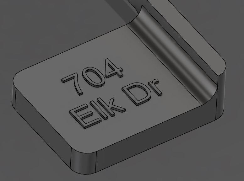 3D rendering of a rectangular plaque with the text '704 Elk Dr' engraved on it.