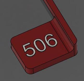 Red plastic object with the number 506 engraved.